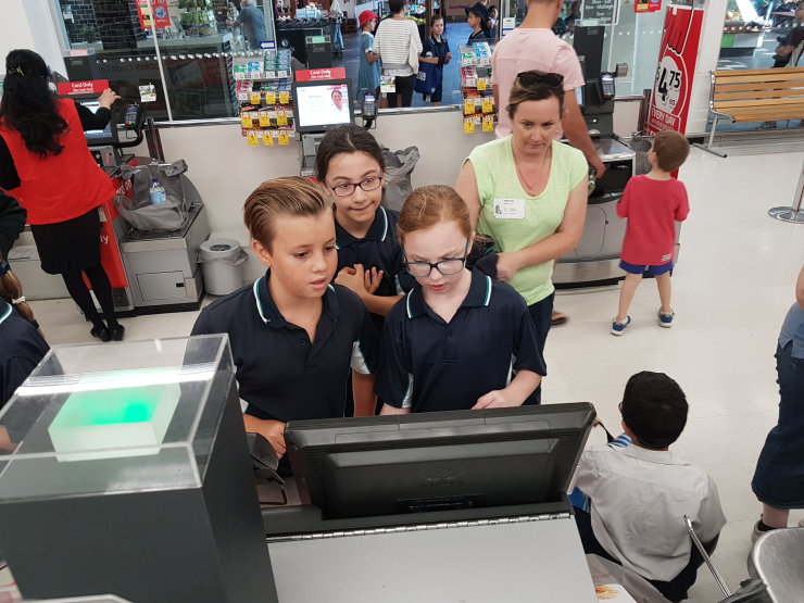 Julian, Jada and Alannah at the cash register paying for their goods. 