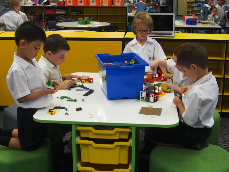 Some boys playing with lego and having fun building.