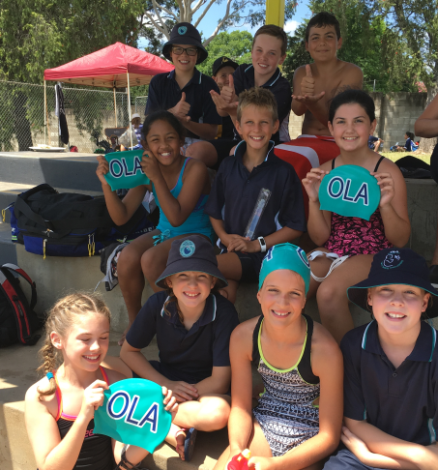 Students showing off our new swimming caps.